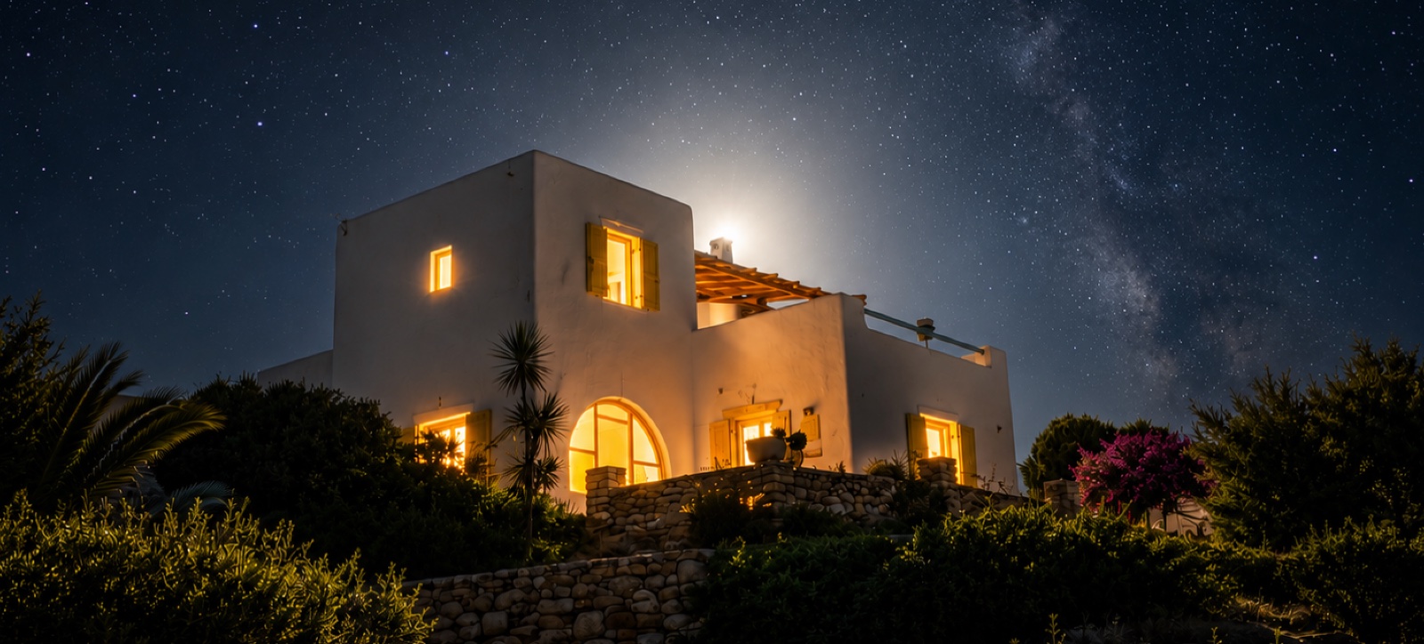 Milos House lit up at night under a starry Cycladic sky