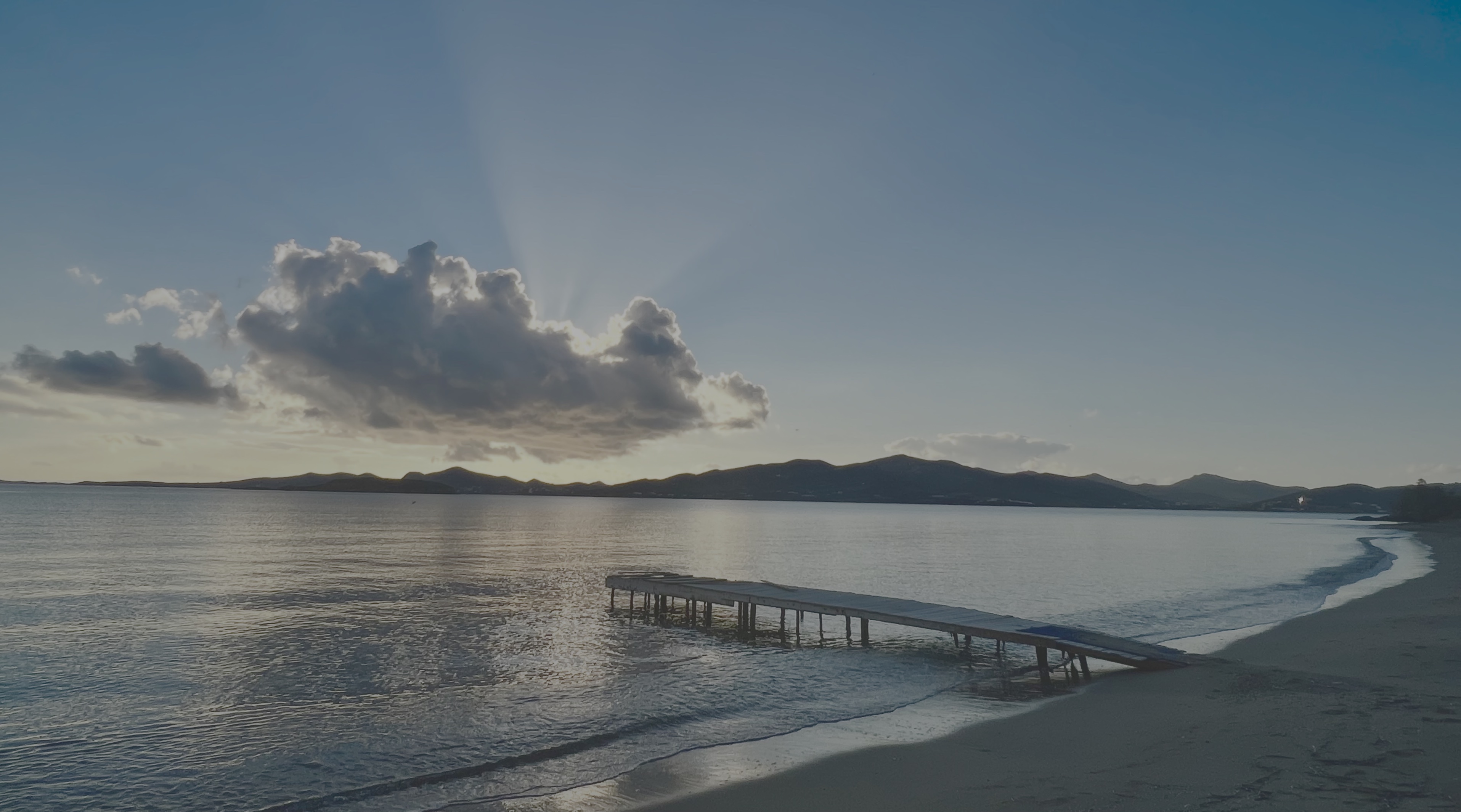 A quiet beach jetty at dusk near Paros