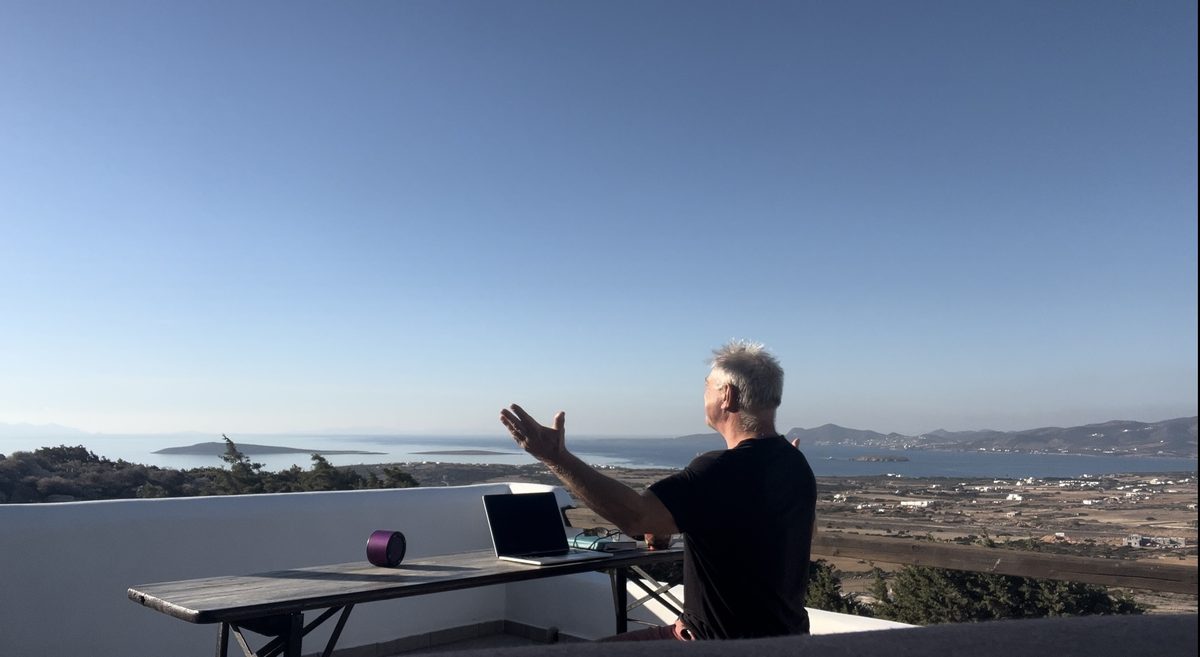 Pete at his writing desk on the terrace, gesturing toward the view